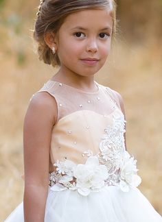 The Arielle Flower Girl Dress from Blush Kids sets the standard for elegance and whimsy in children's formal wear, promising to make any little girl feel like a princess on that special day. A highlight of the dress is its satin bodice, which exudes a timeless grace, perfectly complementing the delicate illusion neckline that adds a touch of sophistication. Adorned with 3D floral lace, the dress comes to life with textures that are both visually stunning and tactilely engaging. Sparkling crystal Cream Flower Girl Dress, Custom Flower Girl Dress, Baby Christening Outfit, Girls Communion Dresses, Baby Party Dress, Ivory Flower Girl, Cream Flower, Girls Crown, Flower Girl Crown