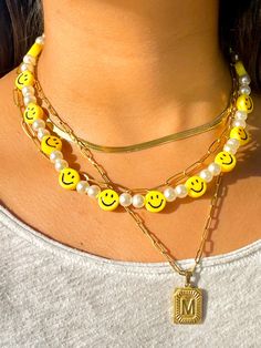 "🙂 Perfect Pearly Smiley Face necklace 🙂 Smiley faces are the new trend this summer. With a mix of white pearls and yellow smiley faces this necklace is here to stay. The \"Smile\" collection is meant to be for anyone who likes to have fun and be spontaneous! Materials: Beaded pearls and Smiley faces Electroplated Plastic Mix 14k gold plated lock and extensor Size: 18 inches or 45 cm Jewelry Care: *Allow perfumes and lotion to dry before wearing. *Remove before showering. *Remove when working Trendy Everyday Pearl Necklace, Trendy Yellow Beaded Chain Necklace, Trendy Yellow Necklace With Beaded Chain, Trendy Yellow Beaded Necklaces, Trendy Yellow Beaded Necklace With Letter Beads, Trendy Pearl Necklace With Letter Beads, Cheap Everyday Smiley Face Jewelry, Preppy Smiley Face Necklaces, Smile Beads Necklace