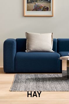 a blue couch sitting on top of a hard wood floor next to a coffee table