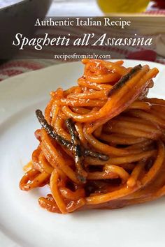 spaghetti with sauce on a white plate and the words authentic italian recipe spaghetti all'assina