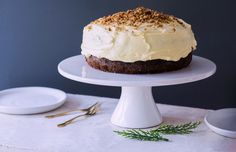 a cake with white frosting and sprinkles sitting on top of a plate