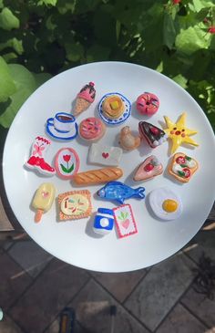 a white plate topped with lots of different types of cookies and pastries on top of a table