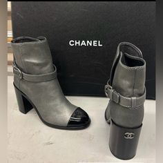 *Nwb Never Worn, 100% Authentic* Chanel Dark Silver/Black Short Boots With A Patent Leather Cap-Toe. This Has A Block Heel Measuring 3.5”, Featuring A Buckle Closure, And The Chanel Logo On The Back Of The Heel And On The Cap-Toe Part. Made In Italy. ***I Am Open To Offers Size: 38 / 8 In U.S. Color: Pewter/Grey & Black Luxury Ankle Boots For Fall, Luxury Fall Ankle Heeled Boots, Luxury Ankle-high Boots For Fall, Winter Designer Leather Boots, Luxury Ankle-high Heeled Boots With Leather Lining, Luxury Ankle Heeled Boots For Office, Chic Gray Winter Boots, Designer Winter Round Toe Heeled Boots, Designer Leather Winter Boots