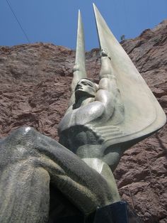 a close up of a statue near a mountain