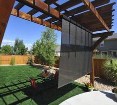 a backyard with grass and wooden pergols