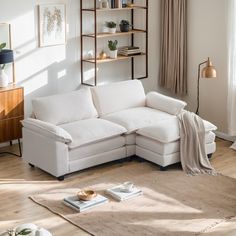 a living room with a white sectional couch and bookshelf on the wall above it