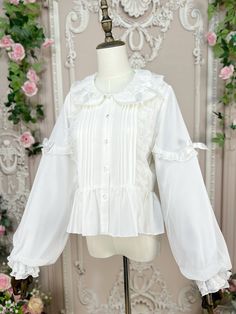 Dress up in this incredibly sweet top that exudes a doll-like charm. The floral bud collar is adorned with delicate lace and a cute bow, adding a touch of elegance. The sleeves feature a unique double-layer design, with a soft fabric layer on the inside and a crinkled chiffon layer on the outside, creating a lovely and whimsical look. The elastic cuffs ensure a comfortable fit, while the irremovable bows on both sides of the sleeves add a playful and adorable touch.  Please note that the price i Cute White Blouse With Doll Collar, White Blouse With Doll Collar In Cute Style, Cute White Top With Lace Collar, Cute White Tops With Lace Collar, Cute White Blouse With Lace Collar, White Collared Feminine Blouse, White Feminine Top With Cute Collar, White Tops With Cute Collar In Feminine Style, Feminine White Top With Cute Collar