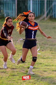 two girls are playing football on the field