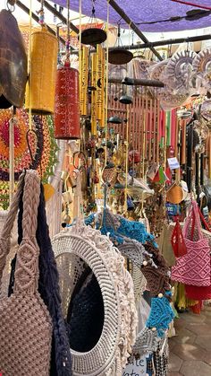 many bags and purses are on display under an awning