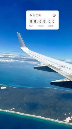 an airplane wing flying over the ocean and land below it with numbers on each side