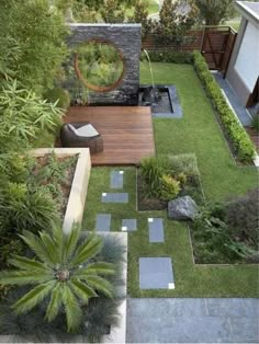 an aerial view of a garden with grass, rocks and plants in the middle of it