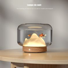 a fish tank with goldfish in it on top of a wooden table next to a white wall