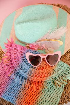 Shade up in style with THE AQUAMARINE SUN HAT! This playful straw hat features cool mint stripes and a sequin sunglasses patch. The white and pink feather and flower combo with sparkling rhinestones adds a touch of whimsy, while the gold band completes the look. Perfect for any sunny day adventure! This hat is ONE OF A KIND, created by our owner Stephanie. To receive item quicker, expedited shipping is available at checkout. Straw Clutch, Pink Feathers, Stand Out From The Crowd, Functional Accessories, Pop Of Color, Rainbow Stripes, Sun Hat, A Rainbow, Gold Band