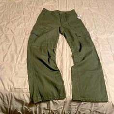 Olive Green New Never Worn Cargo Pants With Functional Equal Pockets On Each Side Green Cotton Cargo Wide Leg Pants, Green Cotton Cargo Style Wide Leg Pants, Green Relaxed Fit Mid-rise Cargo Pants, Green Cotton Utility Wide Leg Pants, Green Cotton Wide Leg Pants With Cargo Pockets, Mid-rise Green Cotton Cargo Pants, Green Mid-rise Cotton Cargo Pants, Green Utility Wide Leg Pants, Casual Green Work Pants With Pockets