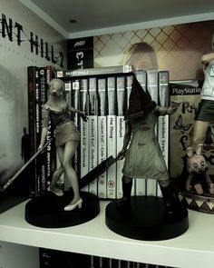 two figurines are on display in front of books