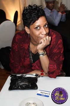 a woman sitting at a table in front of a plate with a badge on it