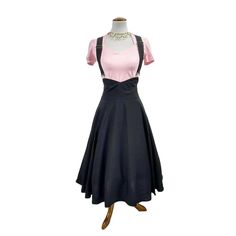 a mannequin wearing a pink and black dress with suspenders on the neck