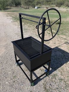 a black cart sitting on top of a gravel field