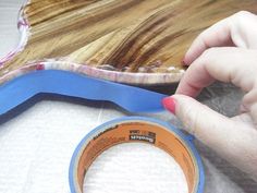 a person holding a blue tape near a wooden board