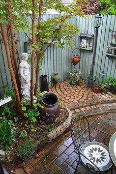 a small garden with a statue in the corner