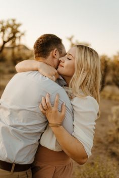 a man and woman embracing each other in the desert