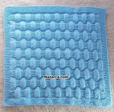 a blue knitted blanket sitting on top of a carpet