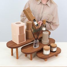 a woman standing next to a table with various items on it