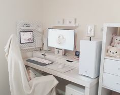 a white desk with a computer on it and stuffed animals in the corner next to it