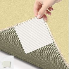 a person is placing a piece of paper on top of a mat that's attached to a wall