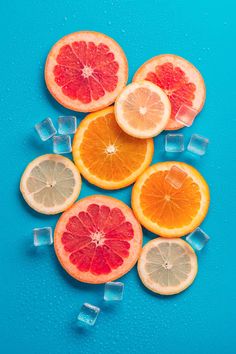 oranges and grapefruit cut in half on ice cubes