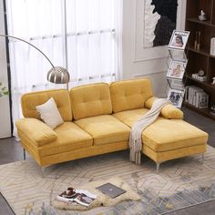 a yellow couch sitting on top of a rug in a living room