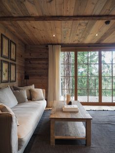 a living room filled with furniture and wooden walls