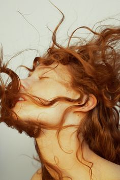 a woman with her hair blowing in the wind