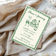 a green and white wedding card sitting on top of a bed