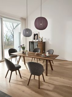 a dining room table and chairs in front of a sliding glass door