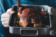 a person holding a tray with chicken in it