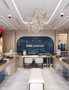 the interior of a jewelry store with chandelier hanging from the ceiling and white chairs