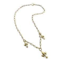 A delicate handmade necklace from the Victorian-era, circa 1890, featuring well-sculpted fleur-de-lis. The chain is made from 14k gold wire, which was hand-twisted into elongated oval links, and then twisted again, halfway, reminiscent of a Mobius strip. Suspended from the chain are three fleur-de-lis in descending size, with the largest in the center of the necklace. Each fleur-de-lis hangs from a wire-twisted round link. This graceful, feminine necklace is 15 1/2 inches long. The largest fleur-de-lis is 3/4 inch, and drops down one inch from the necklace. It weighs 6.75 grams. A spring ring has been recently added for a more secure closure. Elegant Antique Gold Necklaces With Charms, Victorian Gold Necklace With Figaro Chain, Mobius Strip, Feminine Necklace, Elongated Oval, Handmade Chain, One Inch, Gold Wire, Handmade Necklace