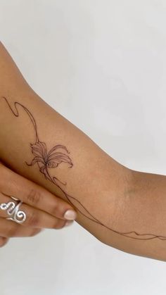 a woman's arm with a flower tattoo on it