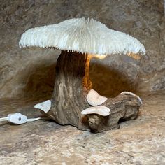 a mushroom lamp sitting on top of a wooden stump next to an earbud