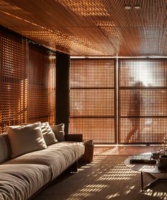 a living room filled with lots of furniture and walls covered in wooden slatting