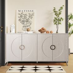 a sideboard with two doors and an area rug on the floor next to it