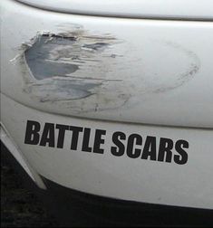 the word battle scars on the side of a white car