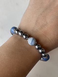 8mm round shaped, polished magnetic silver colored beads with 10mm beautiful light blue agate stone beads with the strongest 7mm magnetic clasp on the market. This bracelet is BEAUTIFUL  Every agate stone is unique.  Relieve wrist or finger inflammation pain safely and naturally!  For most people I would recommend a minimum size of 7" for this size bead. This bead would require you adding at least 1/2" more than your wrist size.  Magnetic Therapy works by creating a magnetic field that penetrate Silver Crystal Bracelet With Agate Gemstone Beads, Silver Agate Crystal Bracelet With Gemstone Beads, Silver Agate Gemstone Beads Crystal Bracelet, Silver Stretch Bracelet With Natural Stone Round Beads, Silver Agate Stretch Bracelet Gift, Magnetic Silver Jewelry With Round Beads, Silver Stretch Bracelet With Natural Stones, Silver Stretch Bracelet With Natural Stones And Round Beads, Silver Bracelets With Agate Round Beads