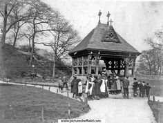 an old black and white photo of people standing in front of a gazebo