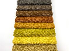 a stack of different colored towels on top of each other in varying sizes and colors