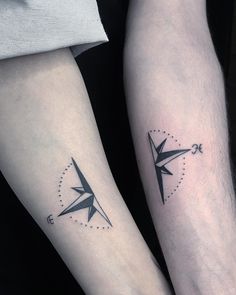 two people with matching tattoos on their arms holding each other's hands and looking at the same direction