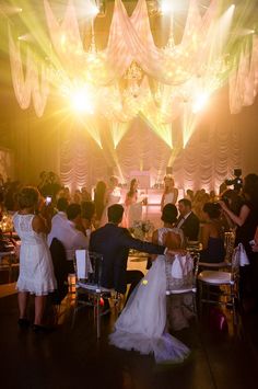 the bride and groom are sitting at their wedding reception table in front of an audience