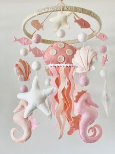 a pink and white mobile with sea creatures hanging from it