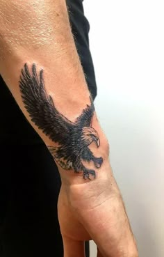 an eagle tattoo on the left hand